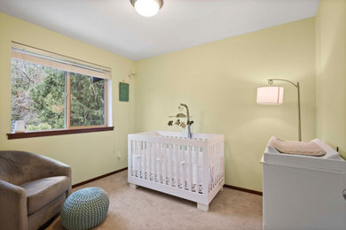 Modelo de habitación de bebé clásica grande con paredes amarillas, moqueta y suelo beige