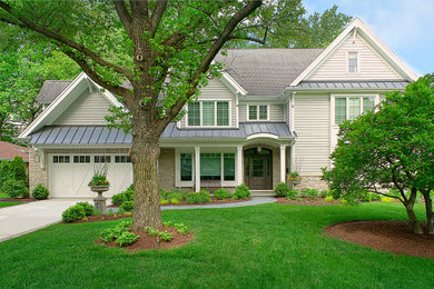Mid-sized beige two-story clapboard and concrete exterior home photo in Chicago with a shingle roof and a brown roof