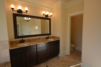 Ejemplo de cuarto de baño principal tradicional renovado pequeño con armarios con paneles lisos, puertas de armario de madera oscura, baldosas y/o azulejos marrones y encimera de granito