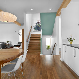 エドモントンの中サイズのミッドセンチュリースタイルのLDKの画像 (白い壁、無垢フローリング、暖炉なし、茶色い床)