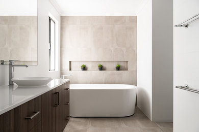 Inspiration for a contemporary master wet room bathroom in Perth with dark wood cabinets, a freestanding tub, beige tile, ceramic tile, beige walls, ceramic floors, a vessel sink, engineered quartz benchtops, beige floor, an open shower and white benchtops.