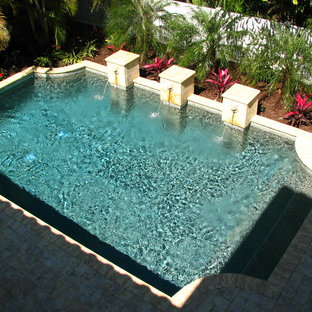 Idéer för mellanstora medelhavsstil rektangulär pooler på baksidan av huset, med en fontän och marksten i tegel