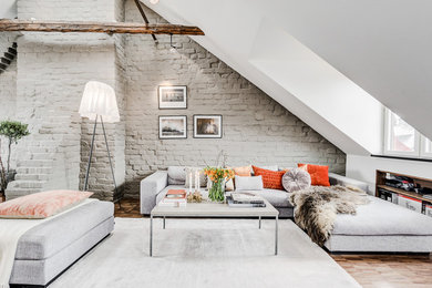 Inredning av ett minimalistiskt stort allrum med öppen planlösning, med vita väggar, mellanmörkt trägolv och brunt golv