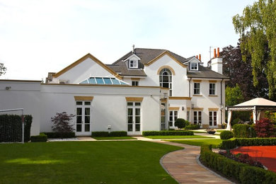 This is an example of a large and white traditional two floor render house exterior in Manchester with a pitched roof.