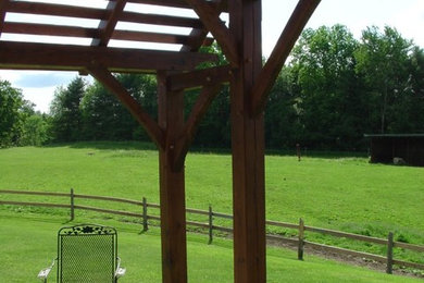 Mid-sized backyard concrete paver patio photo in Burlington with a pergola