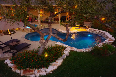 Inspiration for a mid-sized timeless backyard stamped concrete and custom-shaped pool fountain remodel in Austin