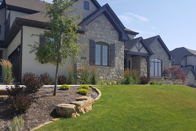 Photo of a mid-sized transitional full sun front yard stone landscaping in St Louis for summer.