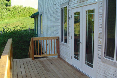 Example of a mid-sized classic backyard deck design in Other with no cover