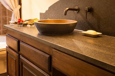 Inspiration for a mid-sized southwestern dark wood floor bathroom remodel in Seattle with raised-panel cabinets, medium tone wood cabinets, granite countertops, a one-piece toilet, yellow walls and a vessel sink
