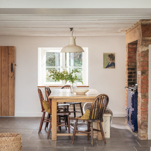 Photo of a medium sized country open plan dining room in Gloucestershire with white walls, slate flooring and grey floors.