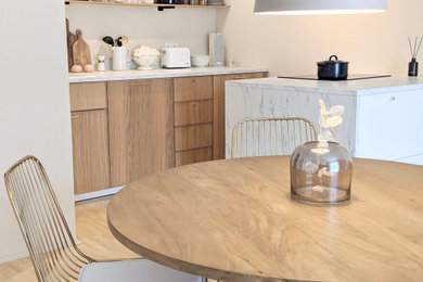 Modelo de comedor de cocina actual de tamaño medio con paredes beige y suelo de madera clara