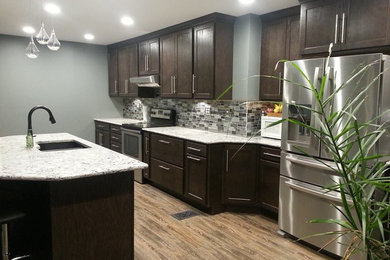 Example of a mid-sized minimalist l-shaped medium tone wood floor and brown floor eat-in kitchen design in Chicago with an undermount sink, shaker cabinets, dark wood cabinets, marble countertops, multicolored backsplash, stainless steel appliances, an island and mosaic tile backsplash