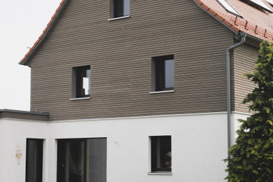 Ejemplo de fachada de casa bifamiliar beige y roja rústica de tamaño medio de dos plantas con revestimiento de estuco, tejado a dos aguas, tejado de teja de barro y tablilla
