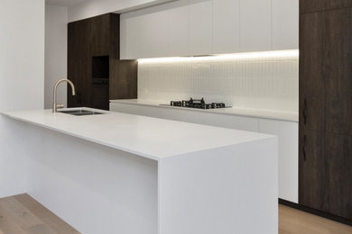 This is an example of a contemporary u-shaped kitchen in Brisbane with white benchtop.