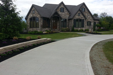 Example of a large mountain style brown two-story stone exterior home design in Cleveland with a shingle roof