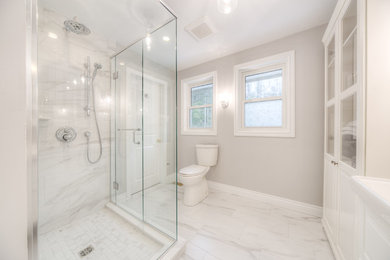 Example of a mid-sized transitional 3/4 white tile and porcelain tile porcelain tile and white floor corner shower design in Toronto with raised-panel cabinets, white cabinets, a two-piece toilet, gray walls, an integrated sink, solid surface countertops, a hinged shower door and white countertops