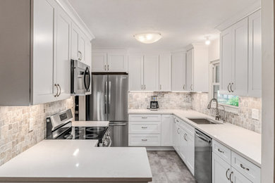 Mid-sized transitional galley enclosed kitchen photo in Columbus with shaker cabinets, white cabinets, quartz countertops, stone tile backsplash and white countertops