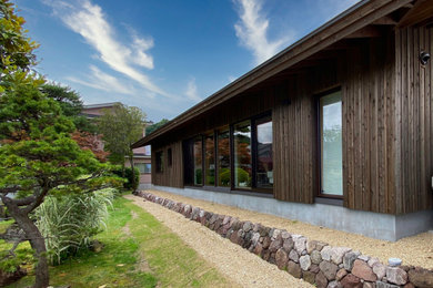 Modelo de fachada de casa gris moderna de una planta con revestimiento de madera, tejado a dos aguas, tejado de metal y panel y listón