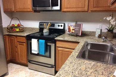 Inspiration for a small timeless u-shaped ceramic tile and beige floor eat-in kitchen remodel in Tampa with a drop-in sink, raised-panel cabinets, medium tone wood cabinets, granite countertops, stainless steel appliances and no island