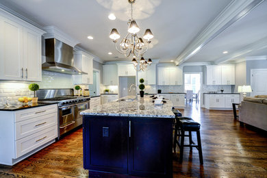 Open concept kitchen - large traditional l-shaped medium tone wood floor open concept kitchen idea in Atlanta with a double-bowl sink, flat-panel cabinets, white cabinets, granite countertops, white backsplash, subway tile backsplash, stainless steel appliances and an island