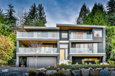 Photo of a modern three-storey stucco grey exterior in Vancouver with a flat roof.