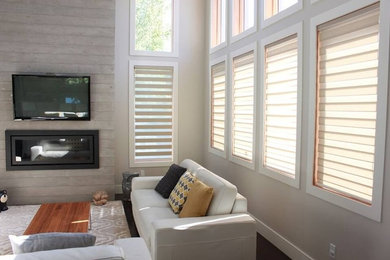 Example of a mid-sized trendy formal and open concept brown floor living room design in Vancouver with beige walls, a ribbon fireplace, a wood fireplace surround and a wall-mounted tv