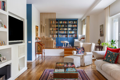 Ispirazione per un soggiorno boho chic con pareti bianche, pavimento in legno massello medio, TV a parete e pavimento marrone