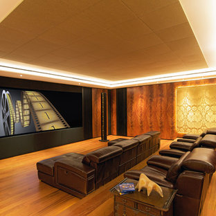 Large contemporary enclosed home cinema in Omaha with brown walls, light hardwood flooring, a built-in media unit and orange floors.