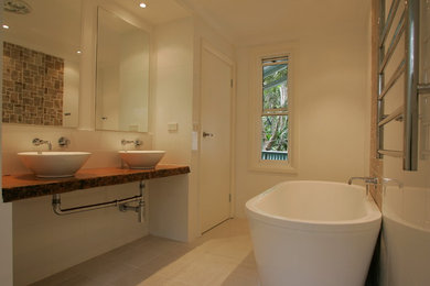Inspiration for a beach style bathroom in Sydney with light wood cabinets.
