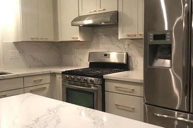 Eat-in kitchen - mid-sized contemporary u-shaped cork floor and brown floor eat-in kitchen idea in San Diego with a single-bowl sink, shaker cabinets, white cabinets, recycled glass countertops, white backsplash and a peninsula