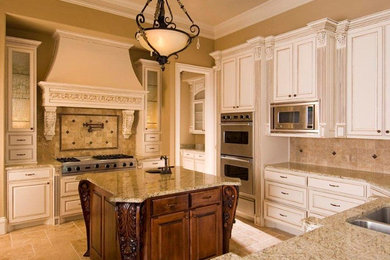 Photo of a mid-sized traditional u-shaped eat-in kitchen in Dallas with a double-bowl sink, raised-panel cabinets, white cabinets, granite benchtops, beige splashback, ceramic splashback, stainless steel appliances, ceramic floors and with island.