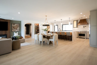 Example of a large transitional laminate floor and beige floor great room design in Phoenix with white walls, a ribbon fireplace and a wood fireplace surround