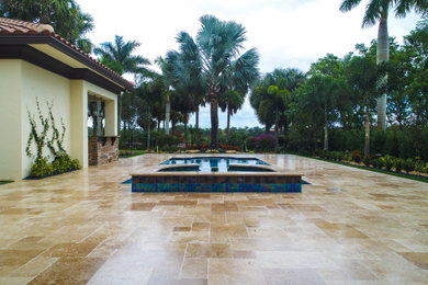 Imagen de piscina clásica grande rectangular en patio con adoquines de piedra natural