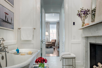 Traditional master bathroom in New York with a claw-foot tub, white walls, marble floors and white floor.