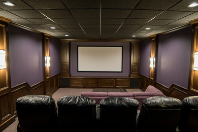 Foto de cine en casa cerrado clásico de tamaño medio con paredes púrpuras, moqueta y pantalla de proyección