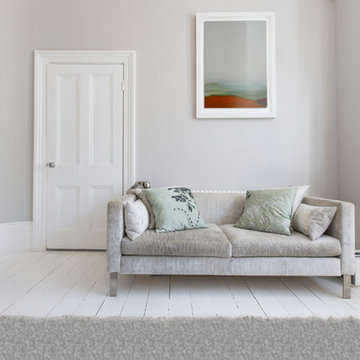 Artwork above white sofa in light filled small living space