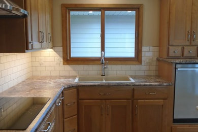 Inspiration for a large craftsman u-shaped light wood floor and brown floor eat-in kitchen remodel in Other with a double-bowl sink, recessed-panel cabinets, brown cabinets, laminate countertops, beige backsplash, ceramic backsplash, stainless steel appliances, an island and brown countertops