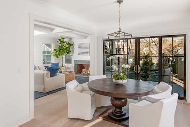 Mid-sized beach style light wood floor and brown floor enclosed dining room photo in New York with white walls and no fireplace