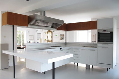 Photo of a mid-sized contemporary open plan kitchen in Berlin with flat-panel cabinets, white cabinets, with island, a drop-in sink and linoleum floors.