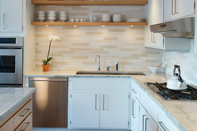 Photo of a mid-sized transitional l-shaped eat-in kitchen in San Francisco with flat-panel cabinets and with island.