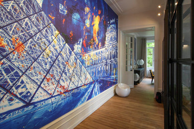 Aménagement d'un très grand couloir contemporain avec un mur bleu et parquet clair.