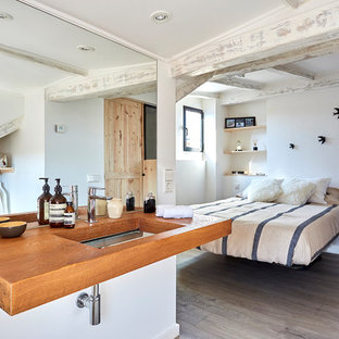 Imagen de dormitorio principal, mediterráneo, de tamaño medio, con paredes blancas, suelo de madera oscura y suelo gris