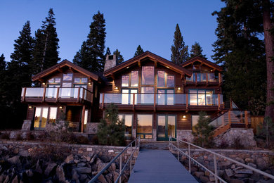 Large mountain style brown three-story wood exterior home photo in Other