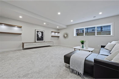 Example of a mid-sized minimalist look-out carpeted and gray floor basement design in Calgary with beige walls