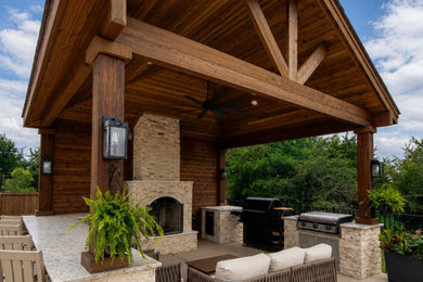 Large backyard stamped concrete patio photo in Dallas with a pergola