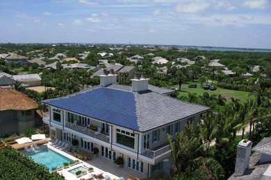 Huge beach style beige two-story stucco exterior home photo in Miami