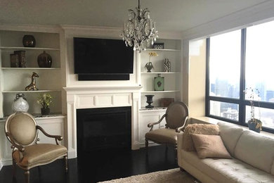 Example of a mid-sized transitional enclosed dark wood floor and black floor living room design in Chicago with beige walls, a standard fireplace, a stone fireplace and a wall-mounted tv