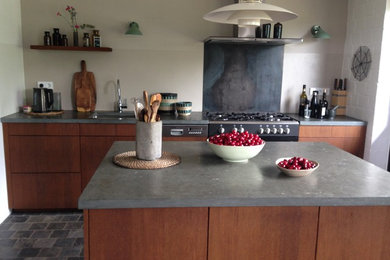 Mittelgroße, Offene, Einzeilige Moderne Küche mit Unterbauwaschbecken, flächenbündigen Schrankfronten, dunklen Holzschränken, Speckstein-Arbeitsplatte, Küchenrückwand in Beige, Küchengeräten aus Edelstahl, Kücheninsel, blauem Boden und blauer Arbeitsplatte in Köln