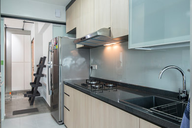 Inspiration for a mid-sized industrial single-wall ceramic tile kitchen pantry remodel in Singapore with a double-bowl sink, flat-panel cabinets, light wood cabinets, granite countertops, black backsplash, mirror backsplash, colored appliances and no island