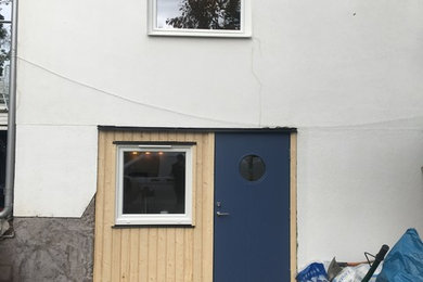 Idéer för små minimalistiska ingångspartier, med vita väggar, heltäckningsmatta, en enkeldörr, en blå dörr och brunt golv